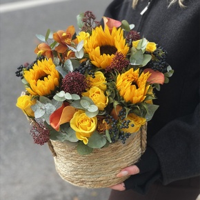 Композиция в сумке "Тональность" из подсолнухов, калл, ягод вибирнума, лимонных роз, скиммии и орхидеи в Яхроме